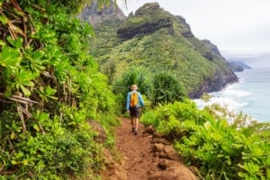 Hiker on the trail in green jungle Hawaii