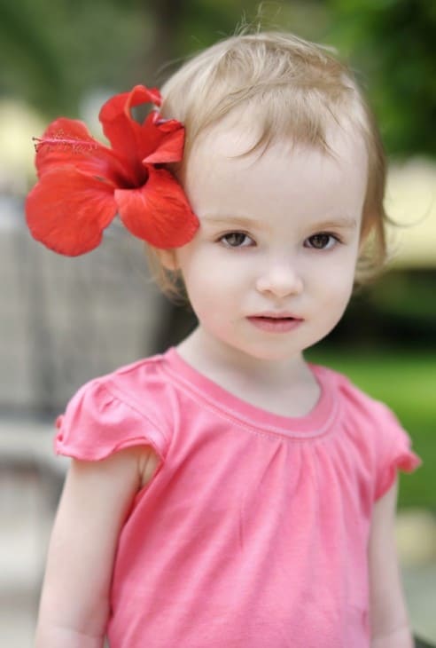 Adorable toddler girl with a hibiscus